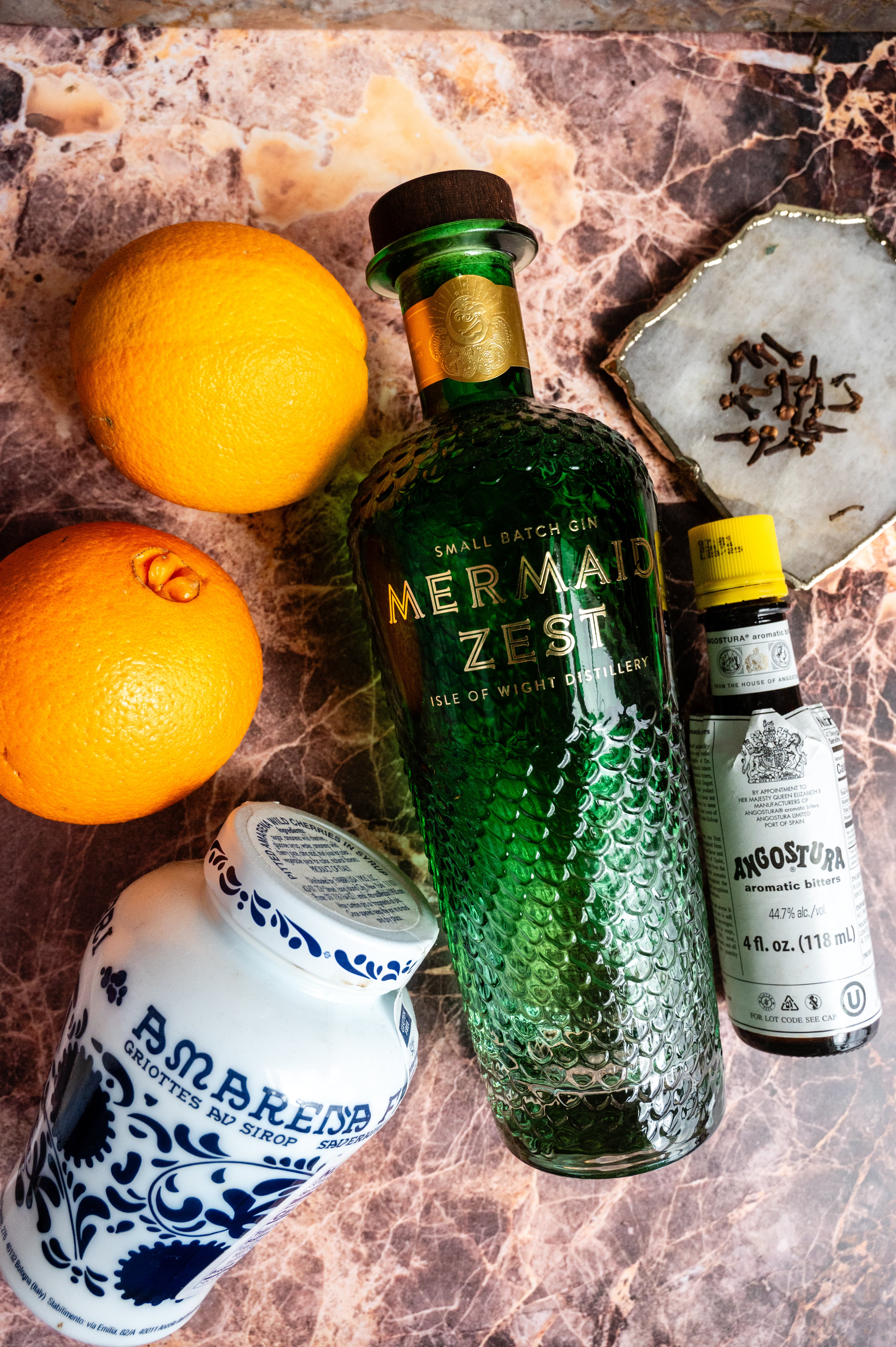 The ingredients for the cocktail on a pink marble table.