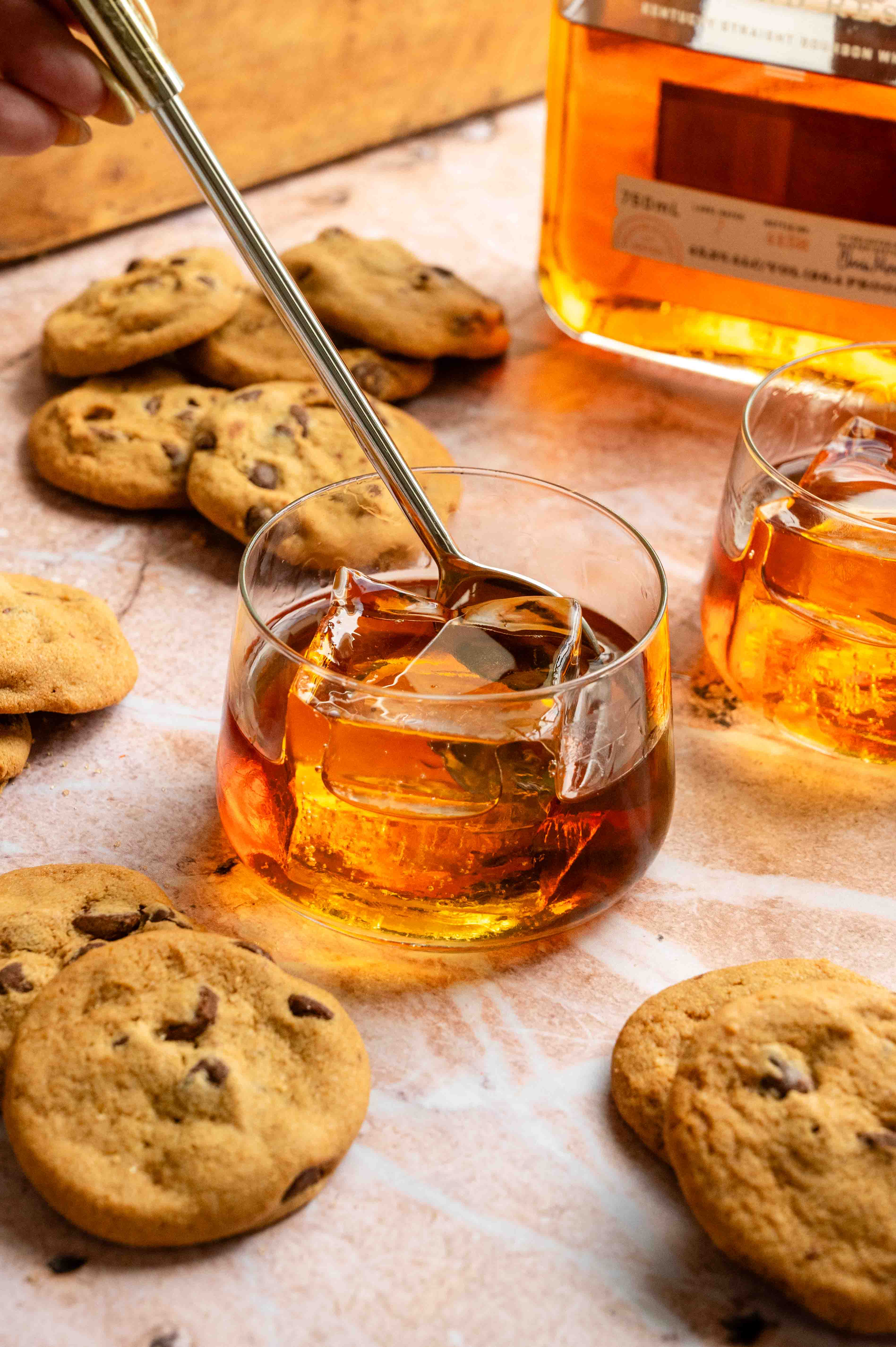 The mixed drink being stirred with a bar spoon.