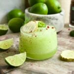A frozen pickle. margarita in low rocks glass and garnished with dill, pickle chips, and jalapeño.