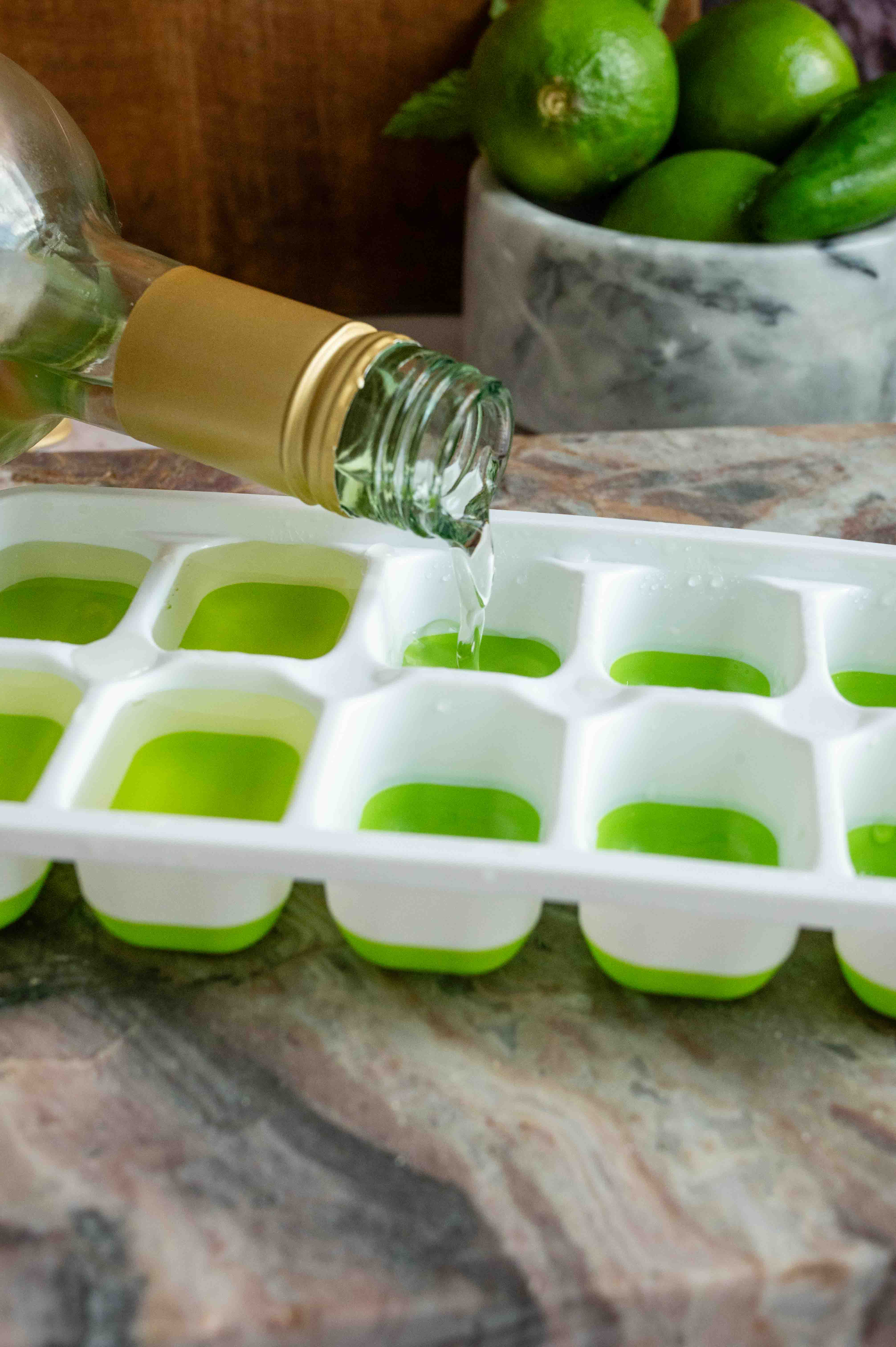 A bottle of Sauvignon Blanc being poured into ice cube molds.
