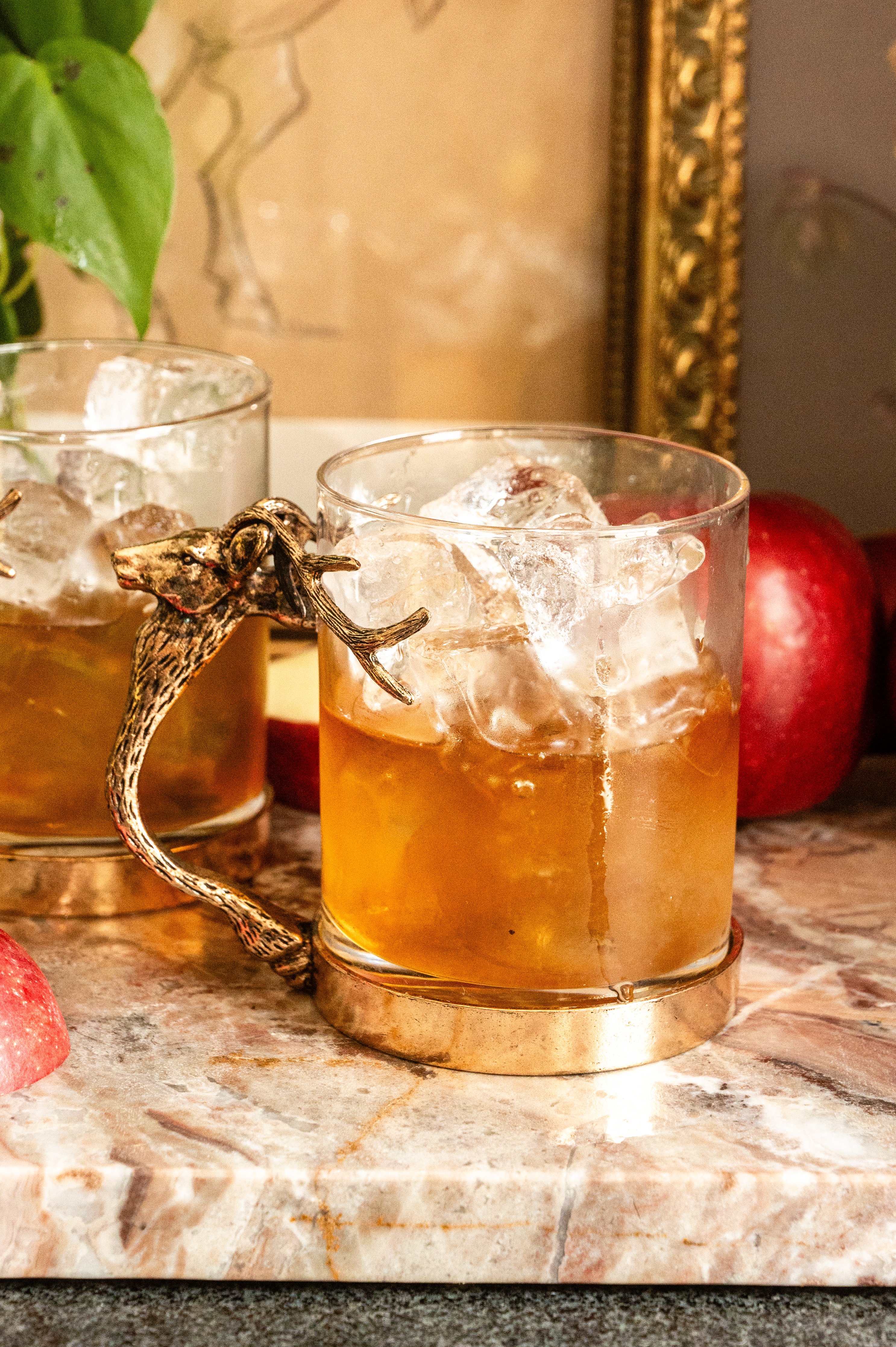 The bourbon lemon juice and syrup in a large rocks glass with a stag head handle.