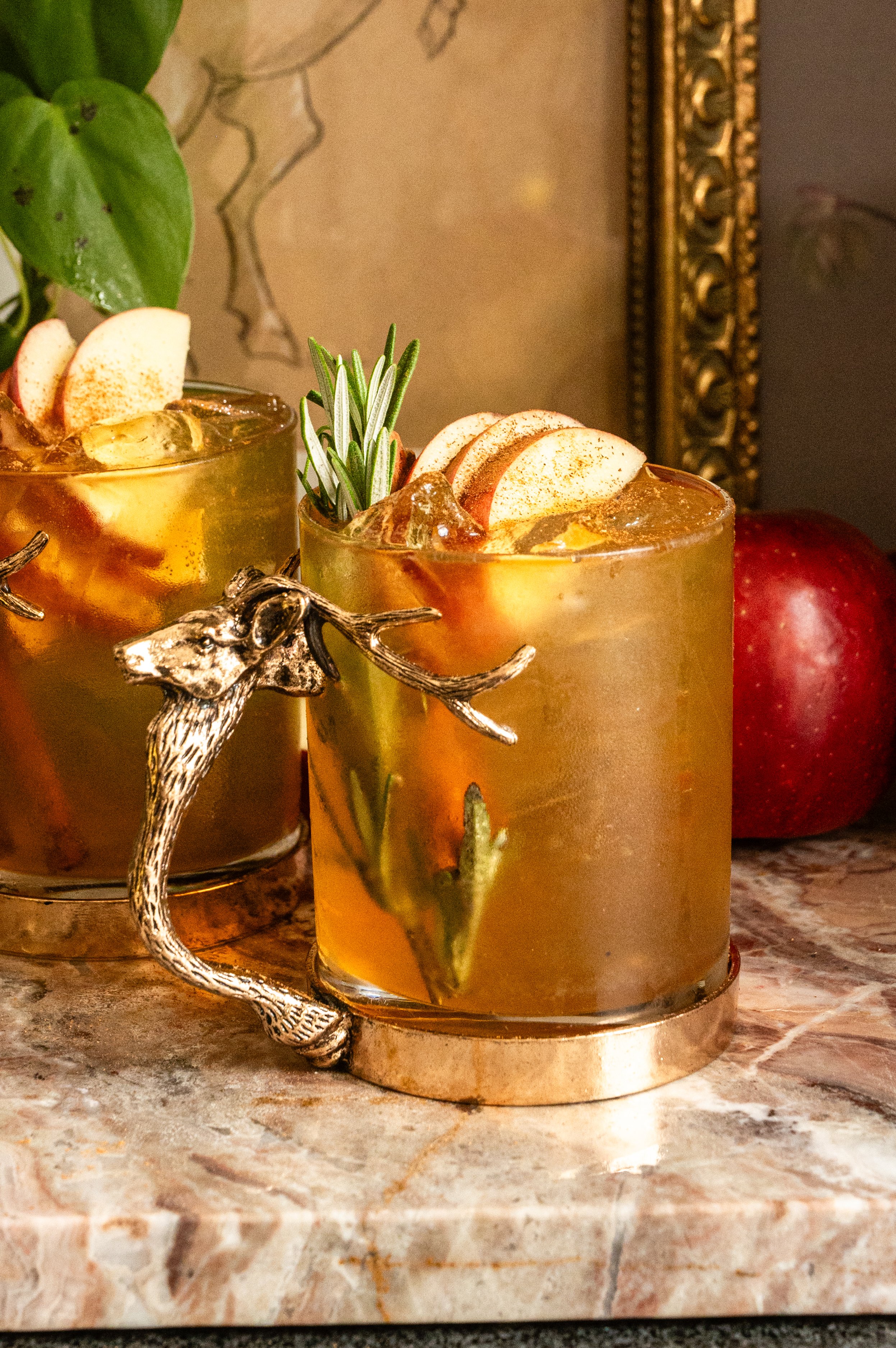 apple crisp mule in a glass mug with a stag handle.