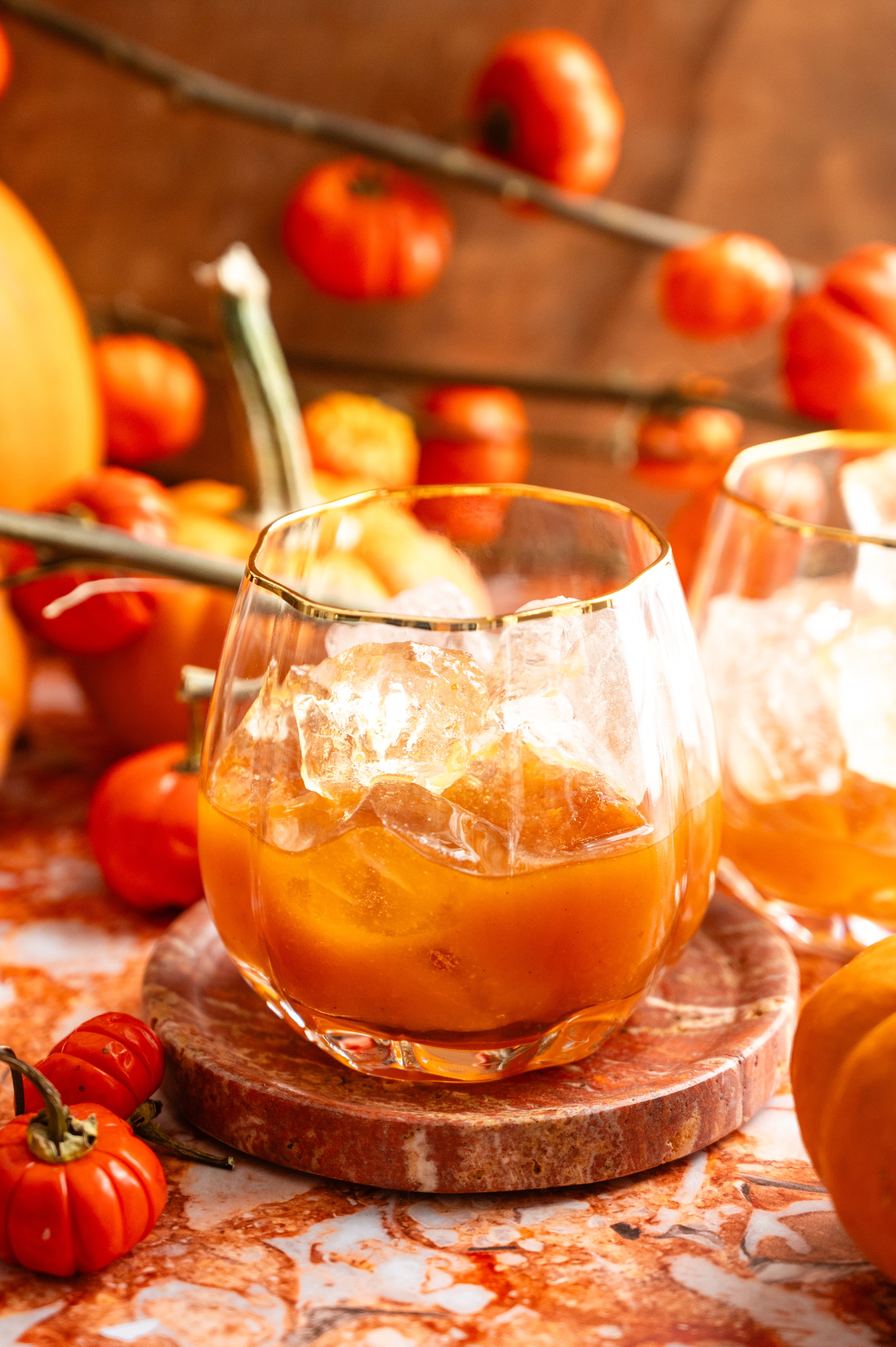 The bourbon pumpkin mixture has been poured into a pumpkin shaped glass. 