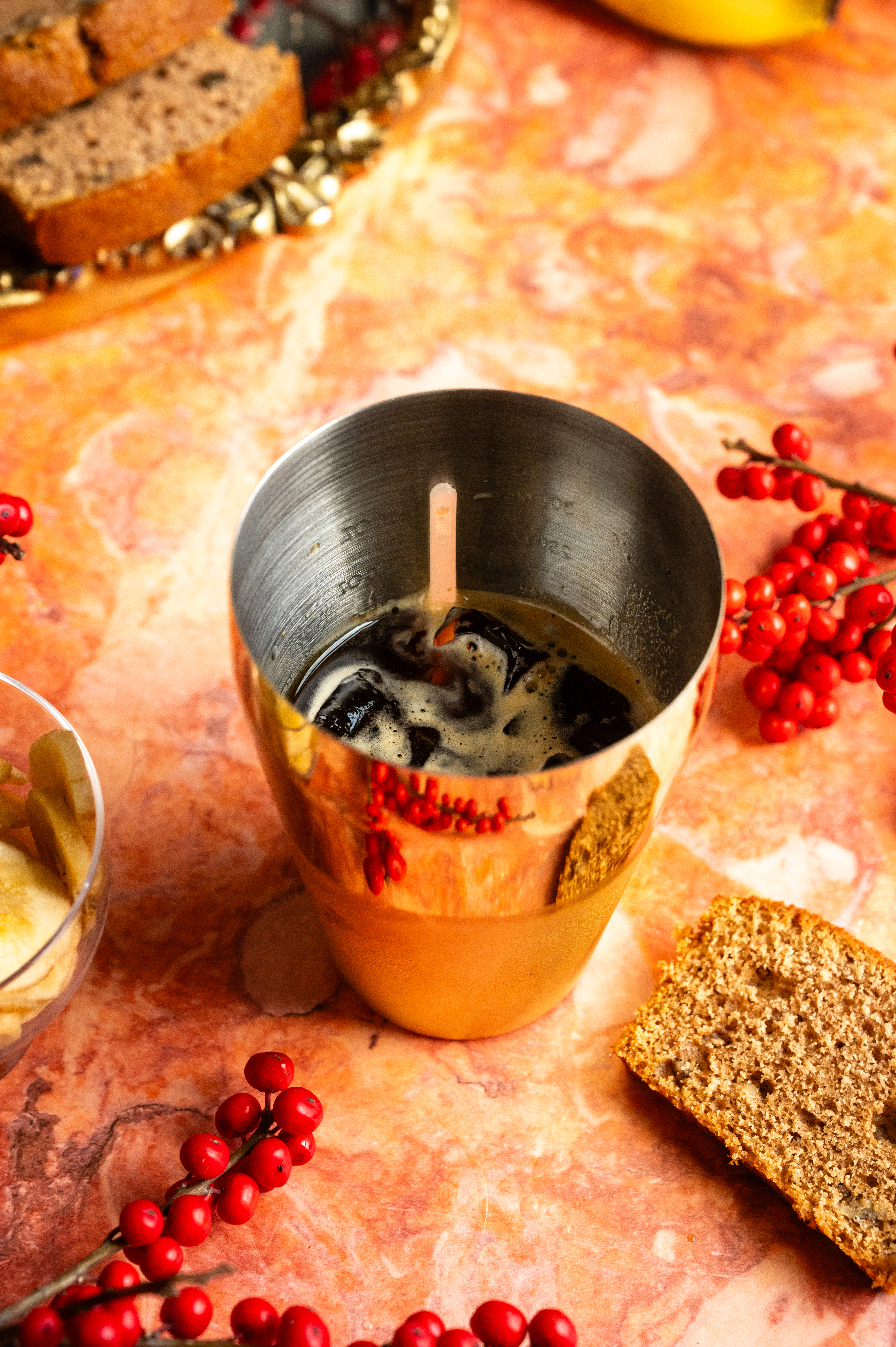 All the ingredients have been added to a. gold. cocktail shaker.