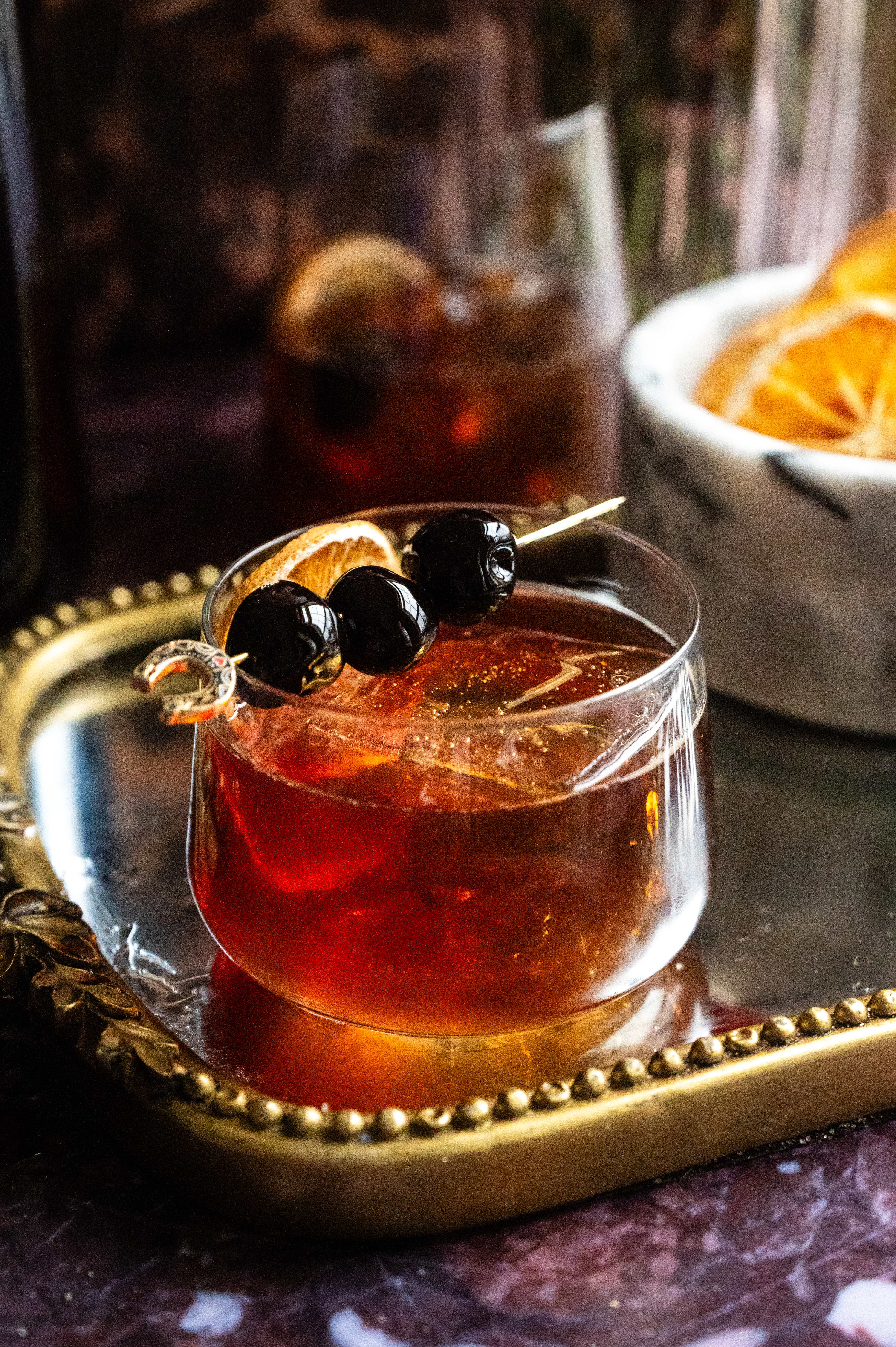 The poured cocktail in a low rocks glass on a mirrored tray.