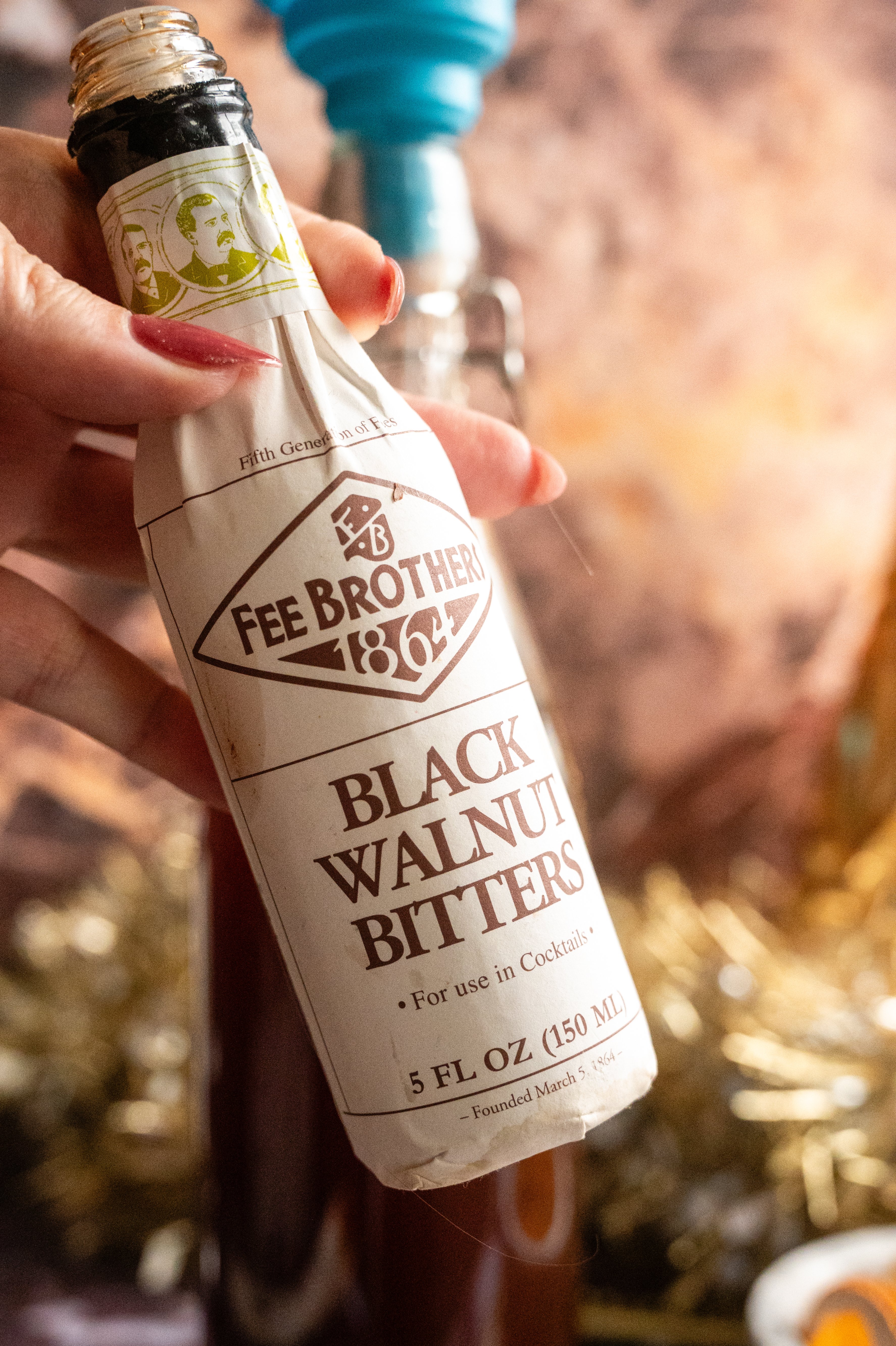 A picture of me holding a bottle of fee brothers black walnut bitters.