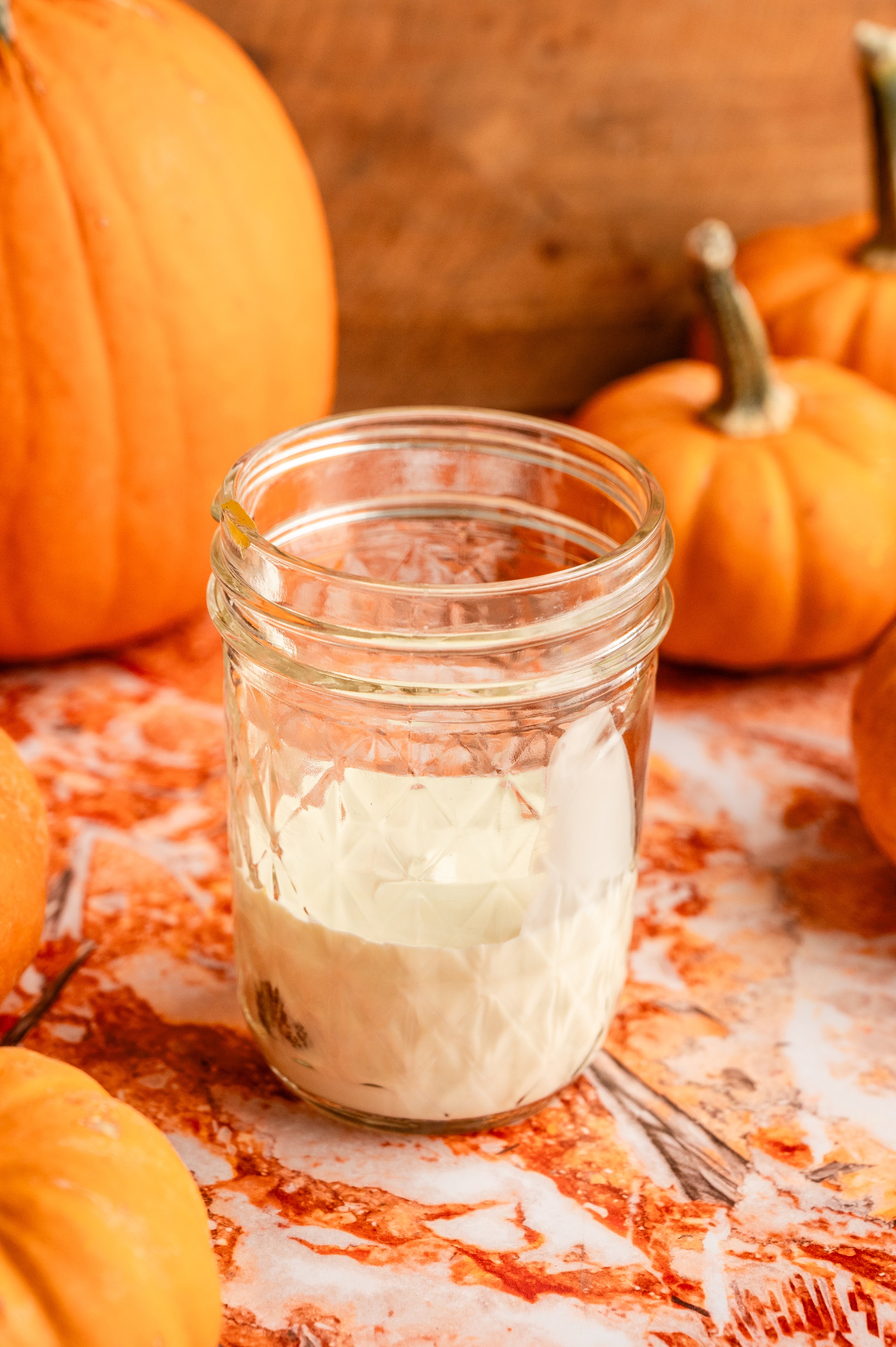 The heavy cream, pumpkin butter, and marscapone in a small glass jar.