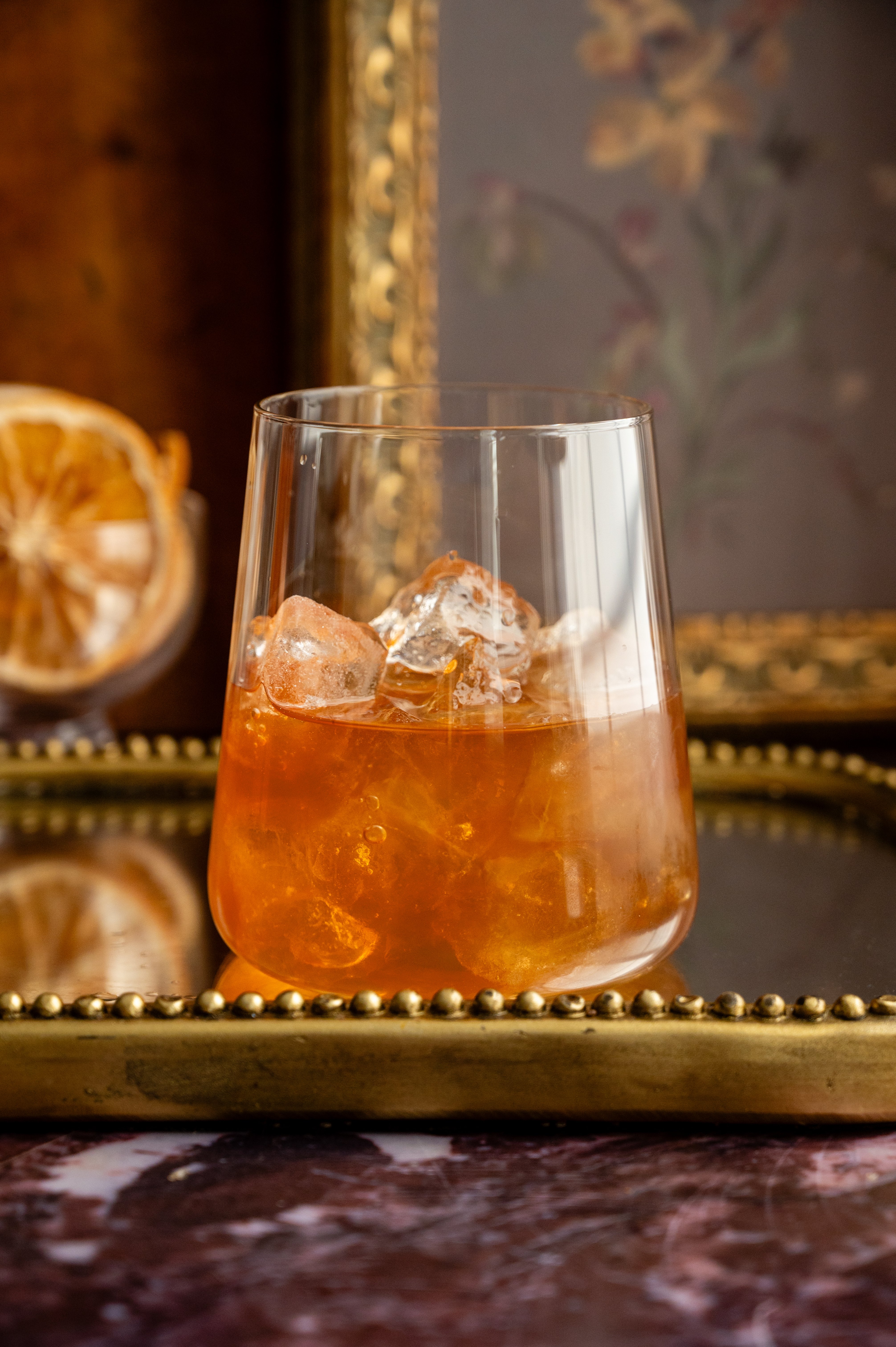 The cocktail has been poured into a large rocks glass with ice.
