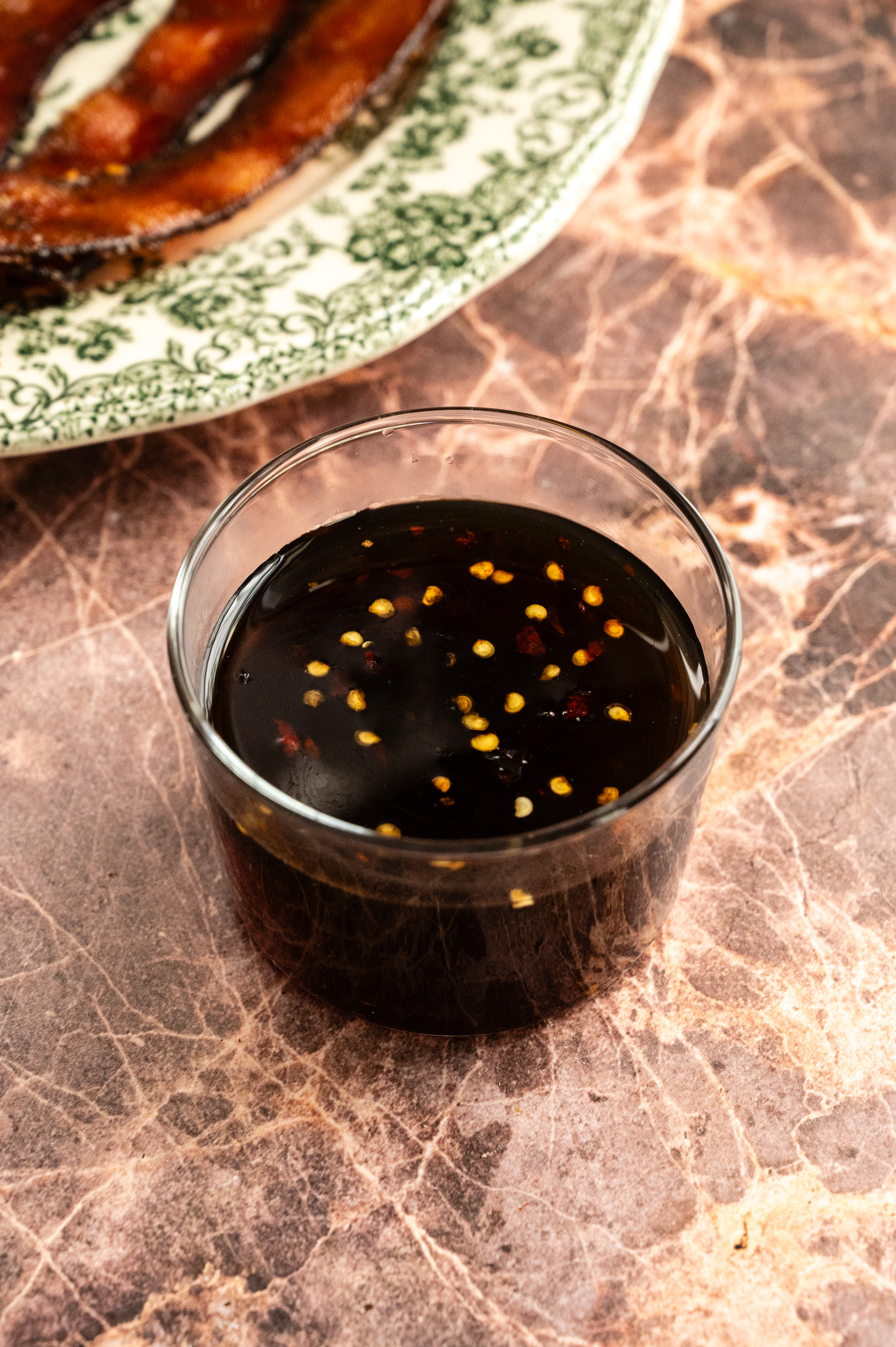 The millionaires bacon glaze sitting in a glass.