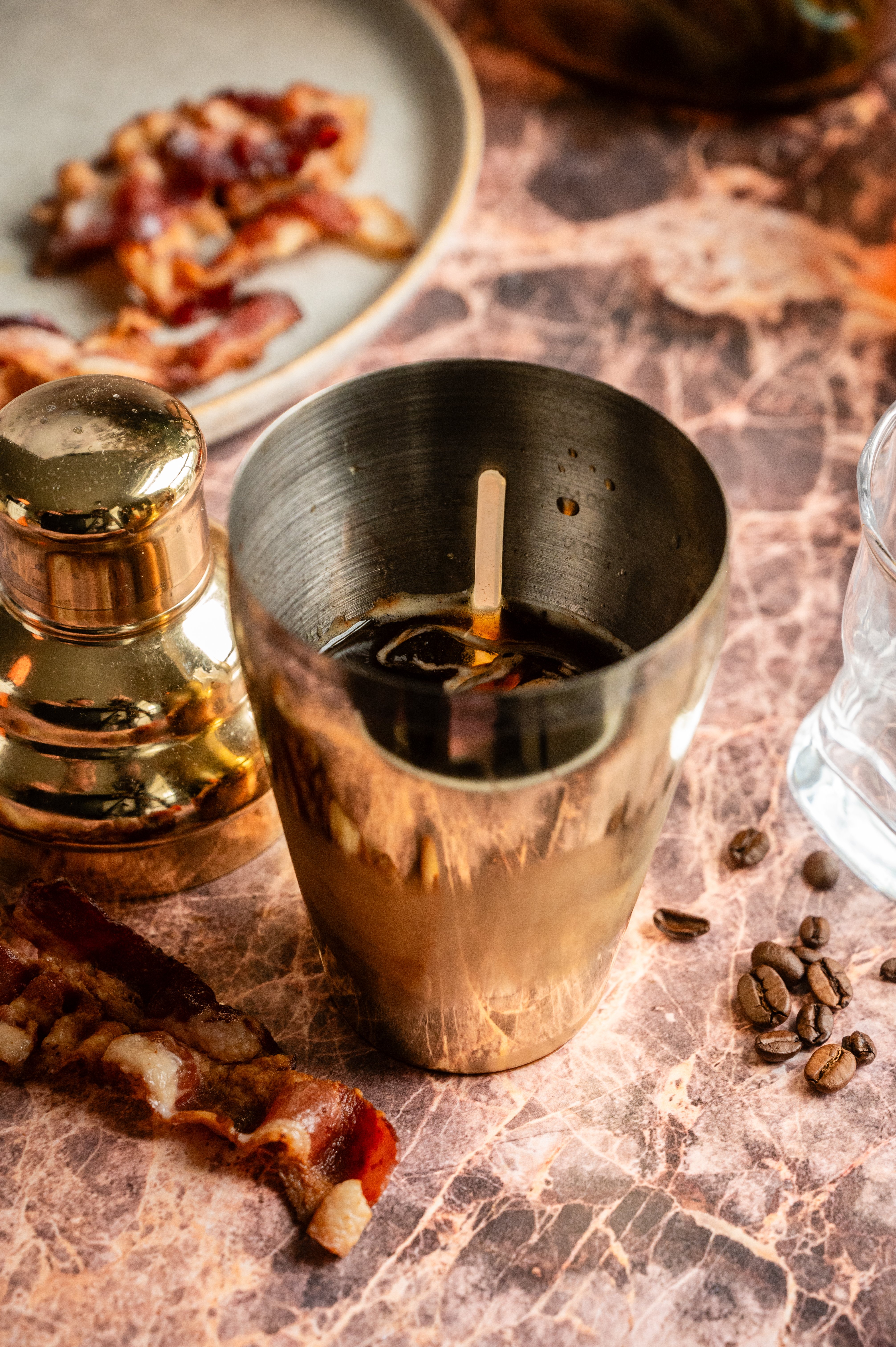 A gold cocktail shaker filled with all the ingredients.