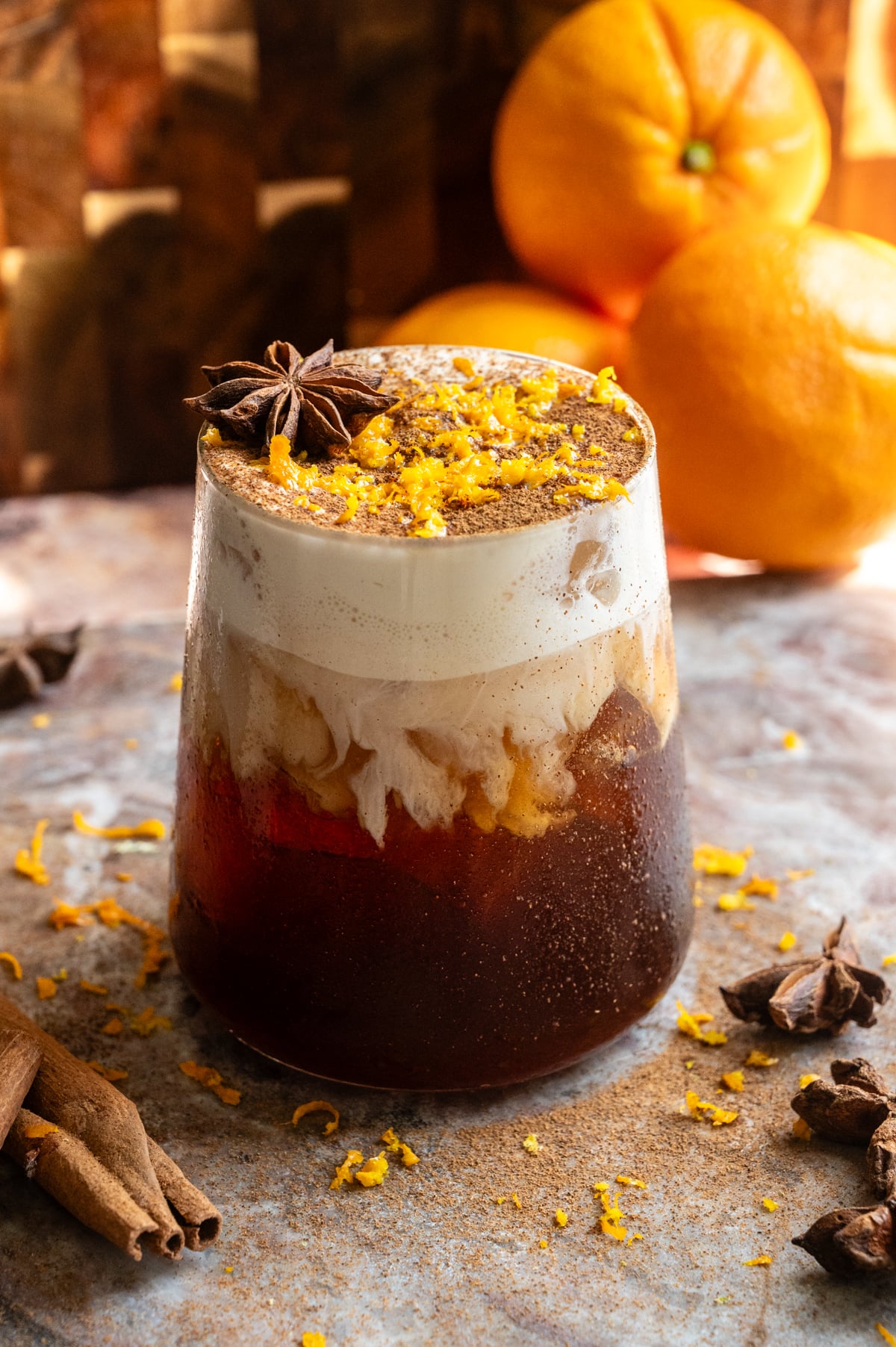 The final cocktail is garnished with a dusting of cinnamon and orange zest.