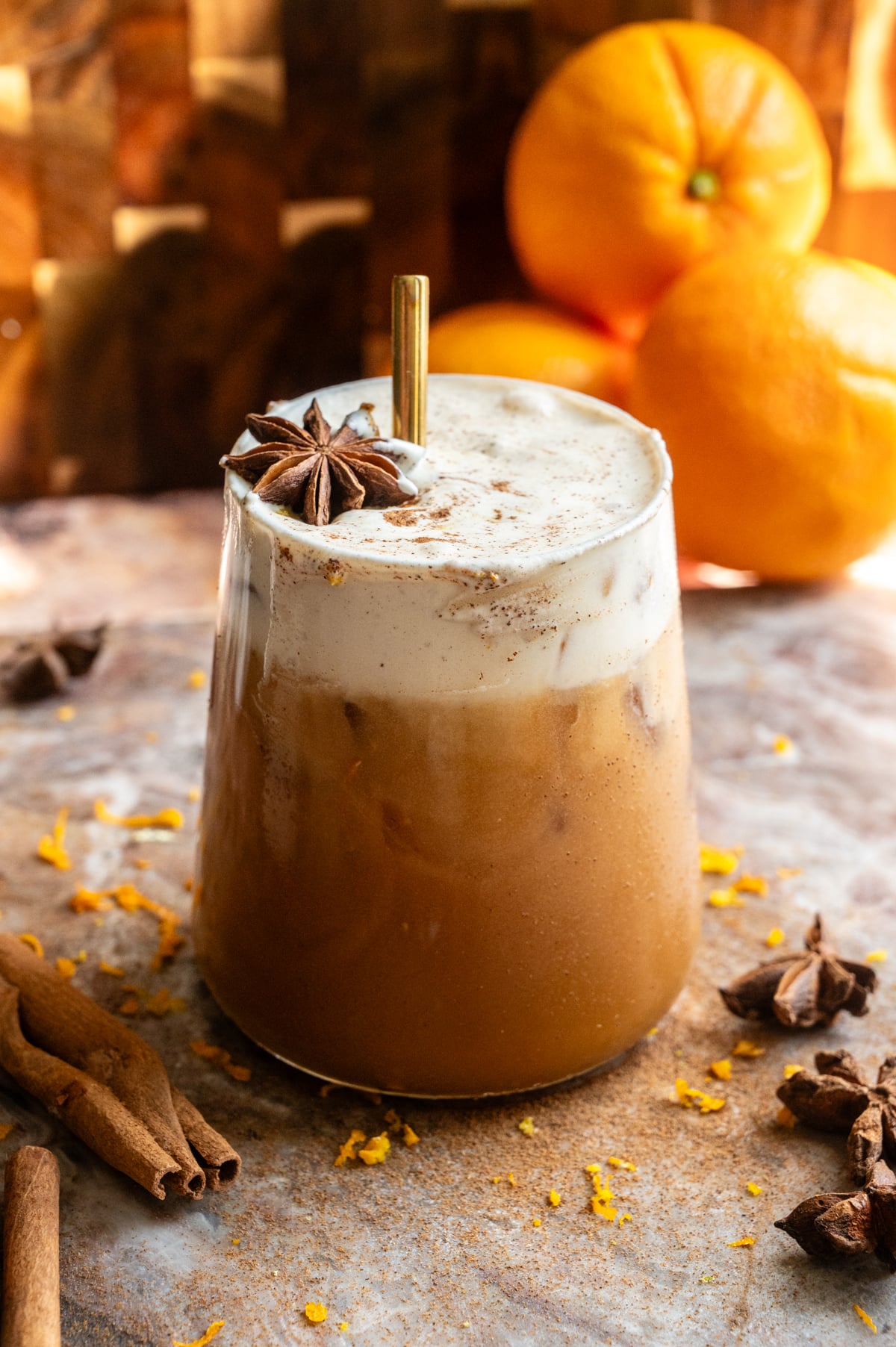 a large rocks glass filled with the carajillo and topped with the cold foam. You can tell its been stirred with a gold straw.
