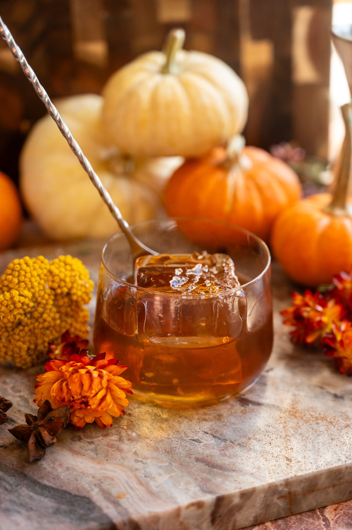 The cocktail is being stirred with a bar spoon.