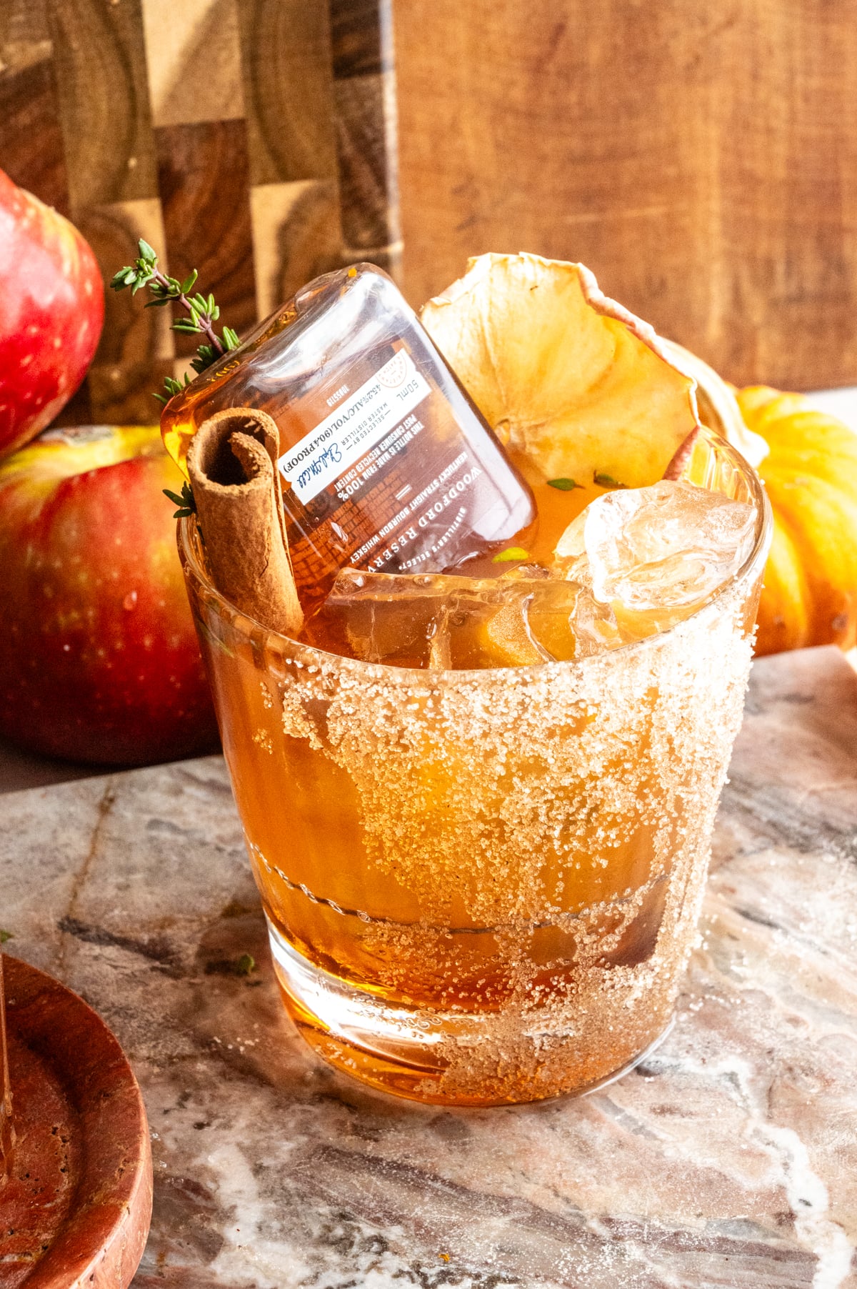 The cocktail with a little bottle of bourbon turned upside down into the drink on a marble slab.