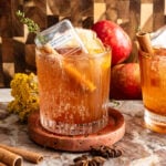 The cocktail with a little bottle of bourbon turned upside down into the drink on a marble slab.