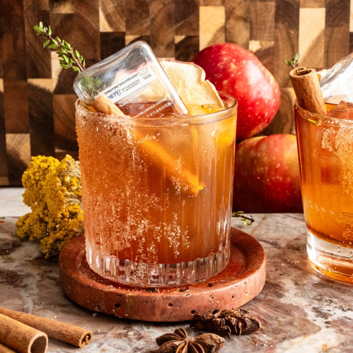 The cocktail with a little bottle of bourbon turned upside down into the drink on a marble slab.