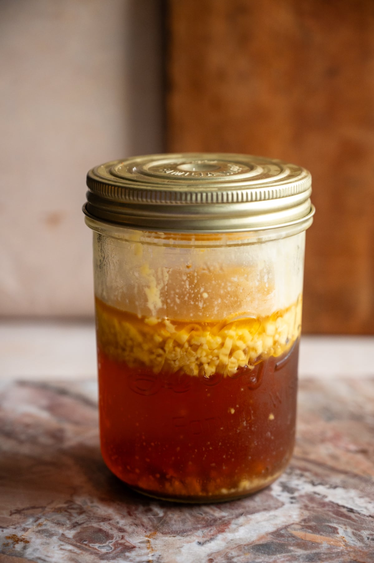 Brown butter fat washed bourbon in a jar with the solidified fat at the top.